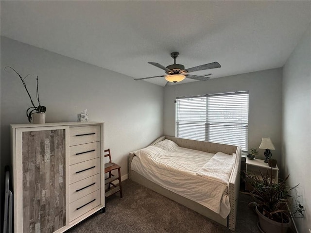 bedroom with ceiling fan and dark colored carpet