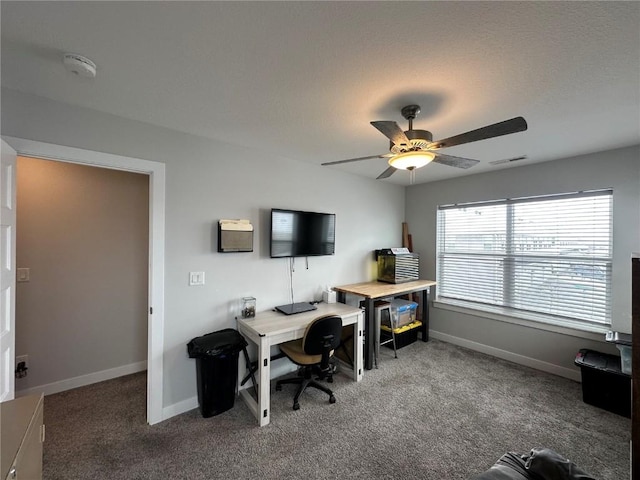 office space with carpet floors, baseboards, visible vents, and a ceiling fan