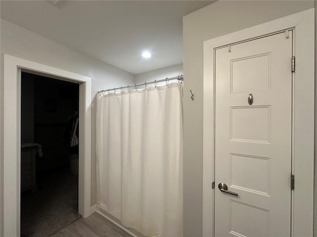 bathroom featuring curtained shower and wood finished floors