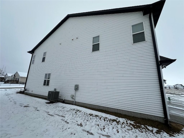 view of snow covered exterior with cooling unit