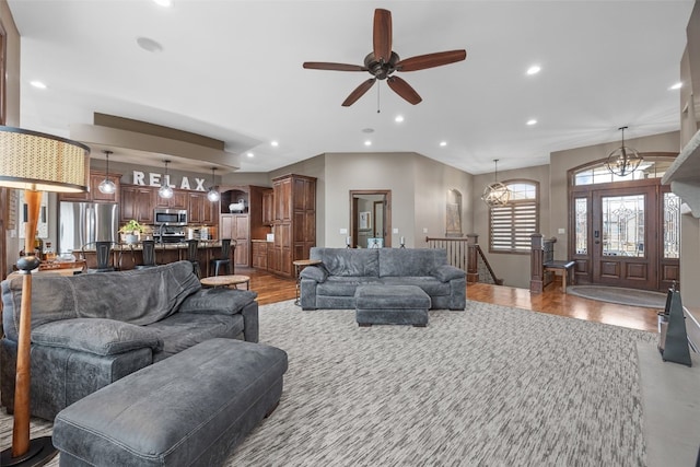 living area with ceiling fan with notable chandelier, wood finished floors, and recessed lighting