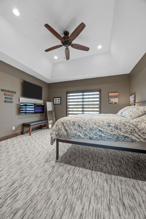 bedroom with baseboards, a raised ceiling, and recessed lighting