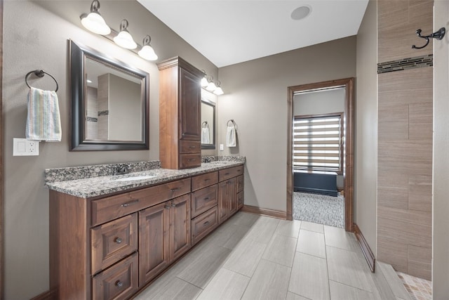 bathroom featuring a sink, baseboards, and double vanity