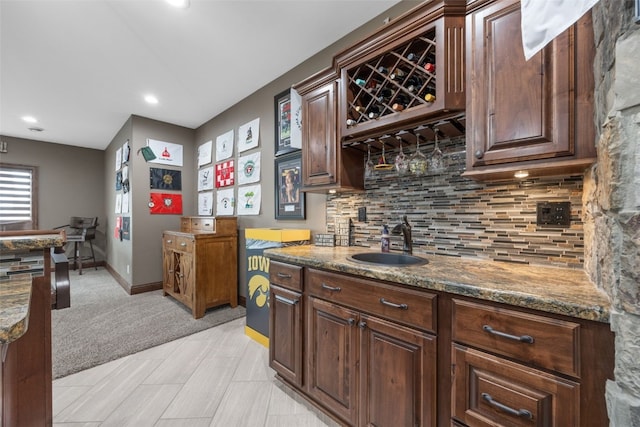 bar featuring recessed lighting, backsplash, a sink, wet bar, and baseboards