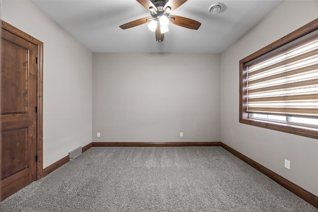 carpeted spare room with ceiling fan, visible vents, and baseboards