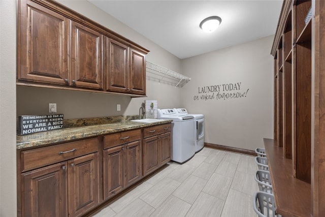 laundry area with washer and clothes dryer, a sink, cabinet space, and baseboards