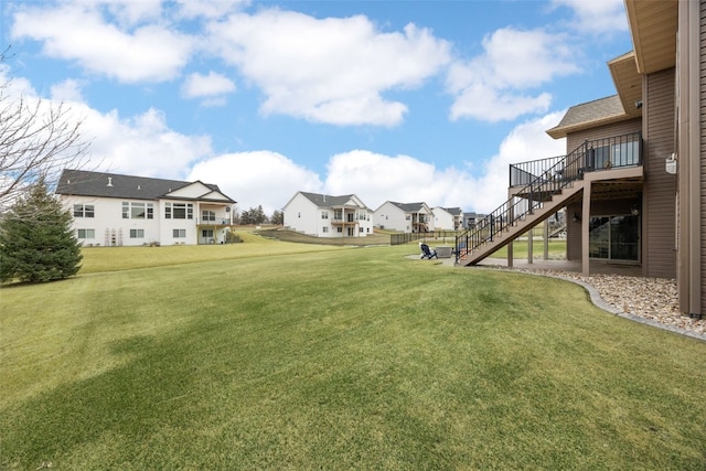 view of yard featuring a residential view, stairway, and a wooden deck