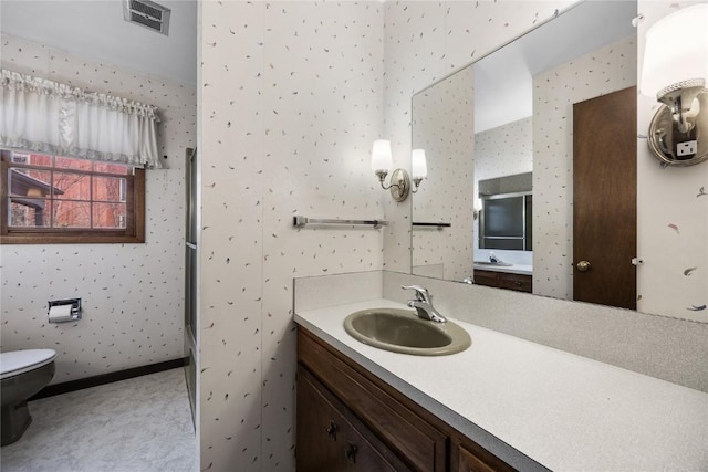 full bath featuring toilet, vanity, baseboards, visible vents, and wallpapered walls