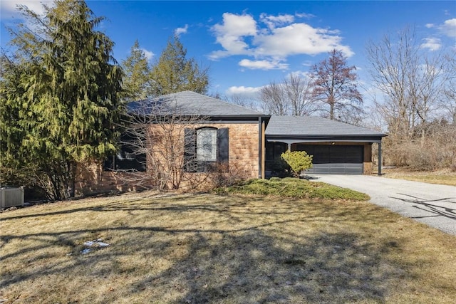 ranch-style home with a garage, concrete driveway, brick siding, and a front lawn