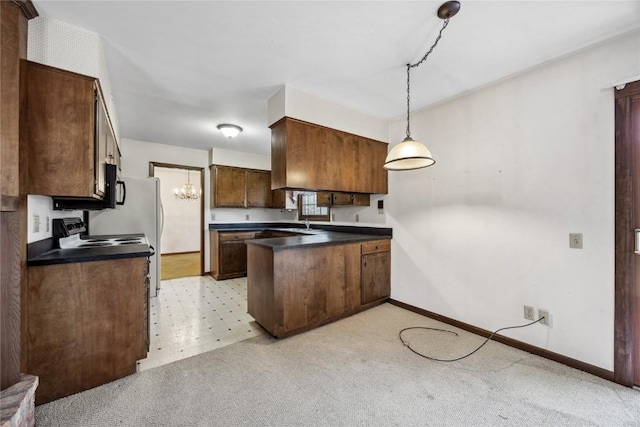 kitchen with pendant lighting, dark countertops, a chandelier, a peninsula, and baseboards