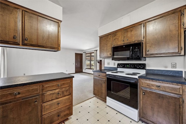 kitchen with electric range oven, light floors, dark countertops, and black microwave