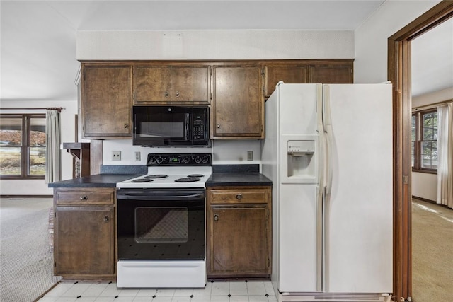 kitchen featuring white refrigerator with ice dispenser, electric range oven, light colored carpet, dark countertops, and black microwave