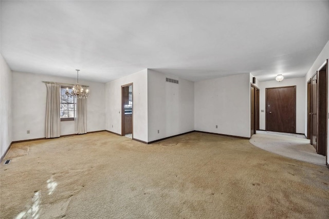 unfurnished living room featuring a chandelier, carpet floors, visible vents, and baseboards