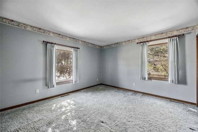 carpeted spare room with visible vents and baseboards