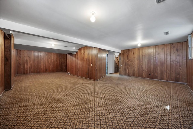 finished basement with wood walls and visible vents