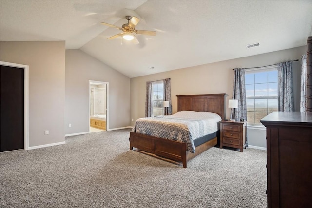 carpeted bedroom with ensuite bathroom, a ceiling fan, visible vents, vaulted ceiling, and baseboards