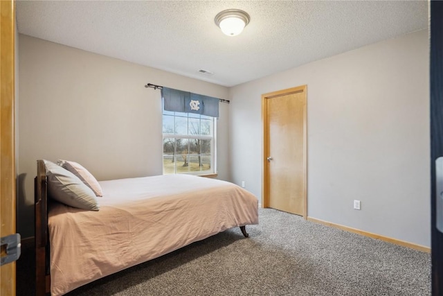 bedroom with a textured ceiling, carpet floors, visible vents, and baseboards