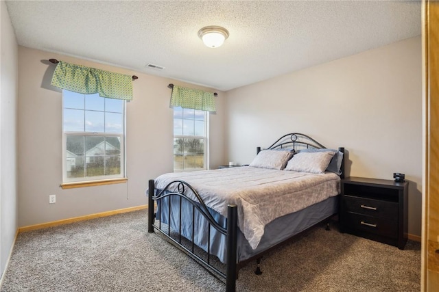 carpeted bedroom featuring visible vents, a textured ceiling, and baseboards