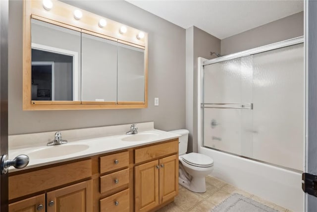 full bathroom featuring double vanity, tile patterned flooring, a sink, and toilet