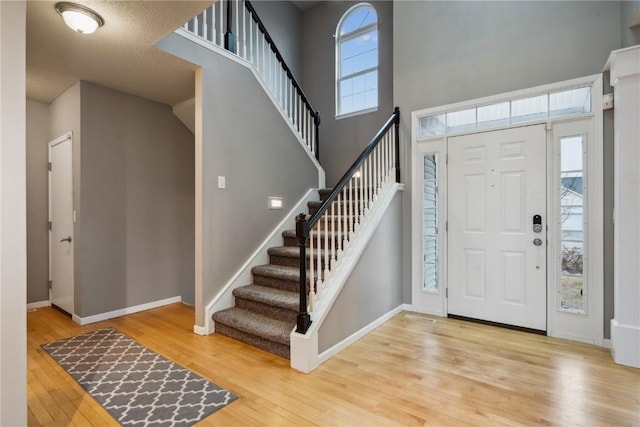 foyer with a healthy amount of sunlight, baseboards, and wood finished floors