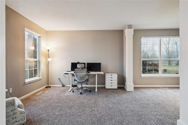 carpeted office space with a textured ceiling and baseboards