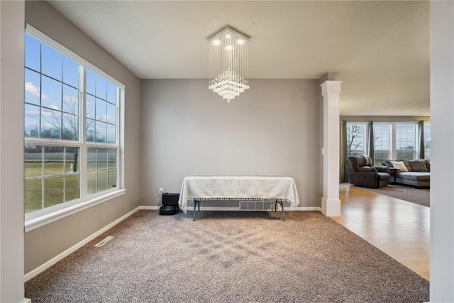 living area with carpet flooring, baseboards, and ornate columns