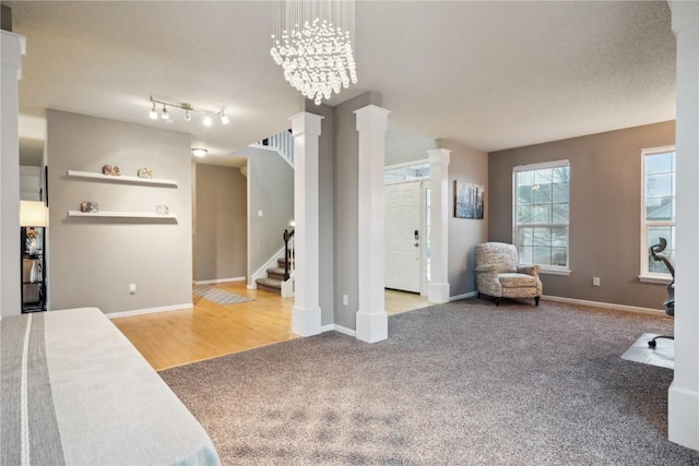 bedroom with baseboards, an inviting chandelier, light colored carpet, and ornate columns