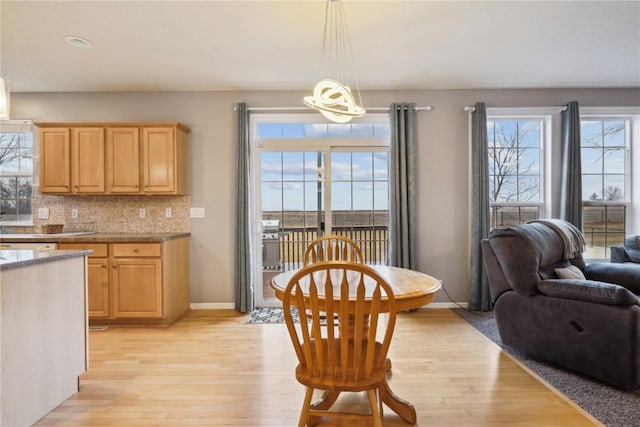 dining space with light wood finished floors, plenty of natural light, and baseboards