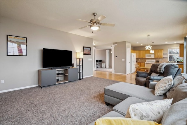 living room with a ceiling fan, recessed lighting, light colored carpet, and baseboards