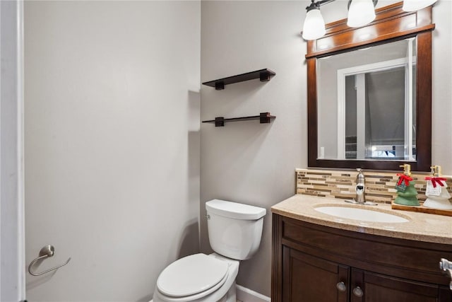 half bath featuring tasteful backsplash, vanity, and toilet