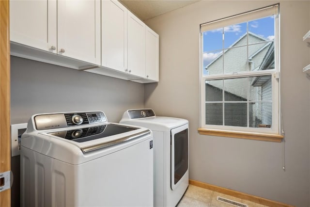 clothes washing area featuring cabinet space, baseboards, visible vents, and separate washer and dryer