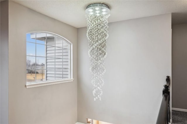 room details with an inviting chandelier, baseboards, and a textured ceiling