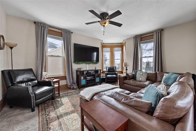 living area with carpet flooring, ceiling fan, a textured ceiling, and baseboards