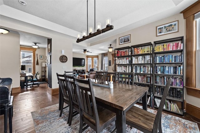 dining room featuring a textured ceiling, ceiling fan, hardwood / wood-style floors, and baseboards