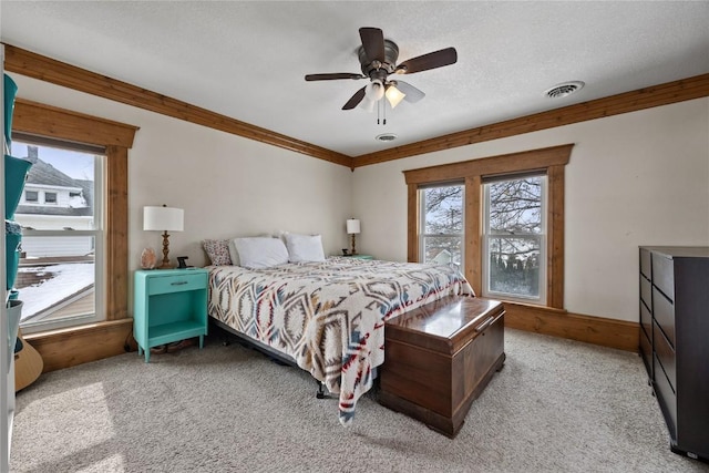 bedroom with a textured ceiling, carpet floors, visible vents, and crown molding