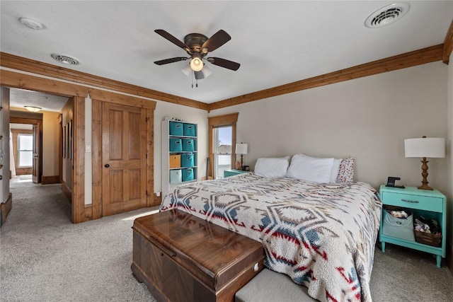 bedroom featuring ornamental molding, carpet flooring, visible vents, and baseboards