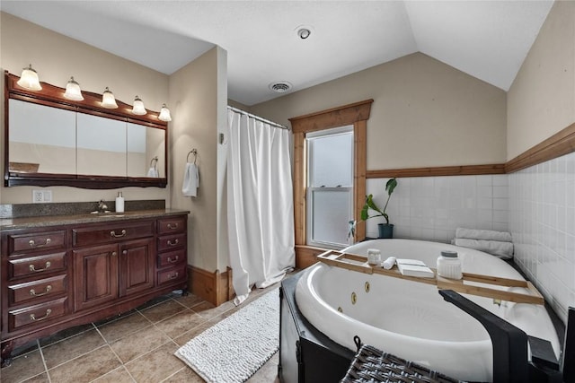 full bathroom with visible vents, a jetted tub, tile patterned flooring, vaulted ceiling, and vanity