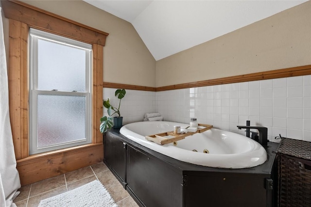 full bathroom featuring lofted ceiling, a healthy amount of sunlight, a jetted tub, and tile patterned floors