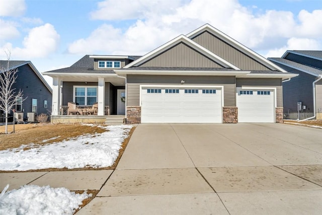 craftsman inspired home featuring a garage, concrete driveway, covered porch, and stone siding