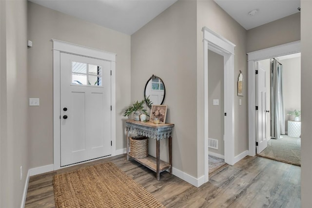 foyer entrance with baseboards and wood finished floors