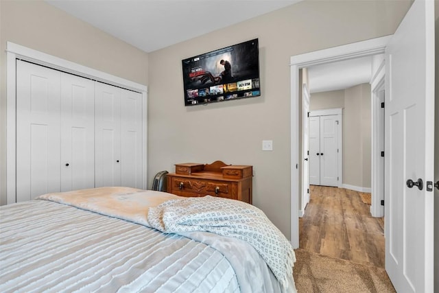 bedroom featuring a closet, baseboards, and wood finished floors