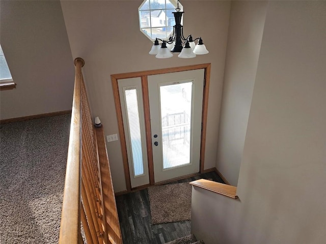 entrance foyer featuring a wealth of natural light, a notable chandelier, baseboards, and wood finished floors