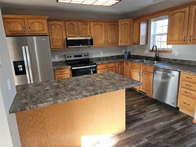203 Maxwell Dr, Shellsburg, IA 52332 - kitchen featuring stainless steel appliances, a sink, dark wood-type flooring, and brown cabinetry