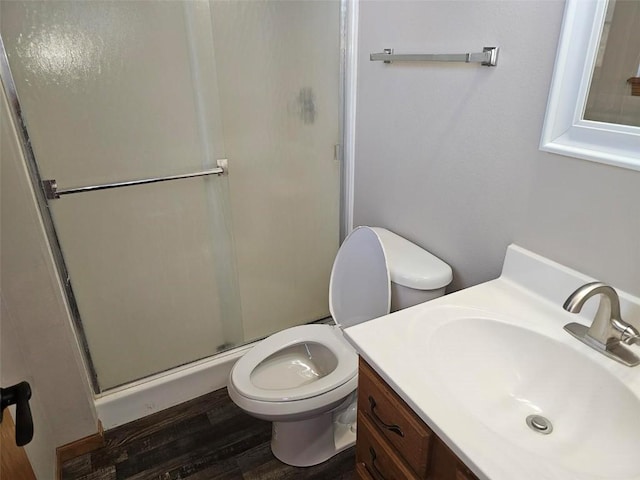 full bath with toilet, a shower stall, wood finished floors, and vanity