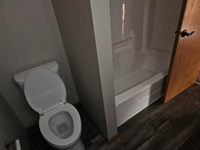 203 Maxwell Dr, Shellsburg, IA 52332 - bathroom featuring toilet, wood finished floors, and washtub / shower combination