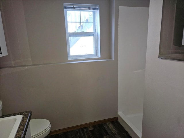 full bathroom featuring toilet, baseboards, wood finished floors, and vanity