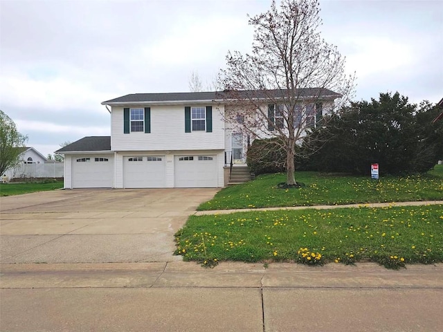 raised ranch with concrete driveway, a front yard, and a garage