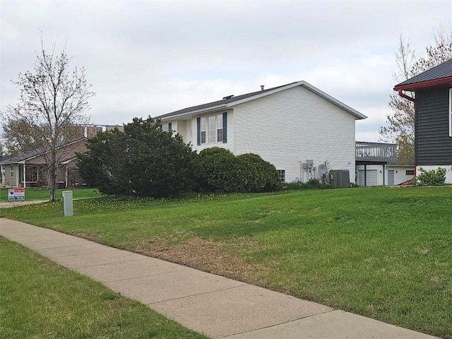 view of side of home with a yard and central air condition unit