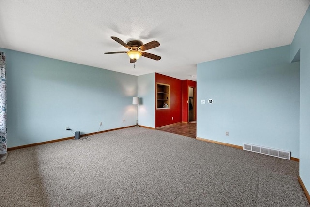 spare room with visible vents, a ceiling fan, carpet flooring, a textured ceiling, and baseboards