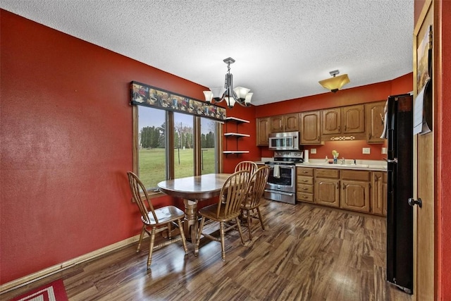 dining area featuring a textured ceiling, baseboards, dark wood-style flooring, and a notable chandelier